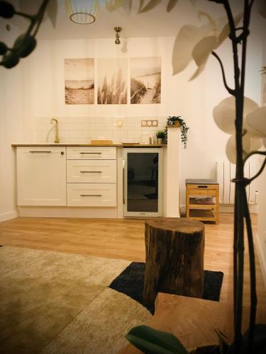 a kitchen with white cabinets and a wooden floor at Suite Spa et Sauna de Cogny in Cogny