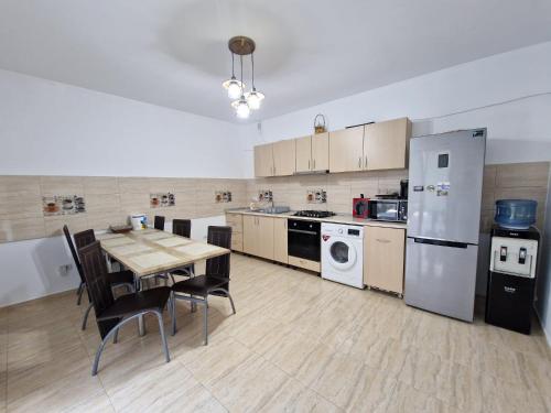 a large kitchen with a table and a refrigerator at Villa Niko in Mamaia Nord