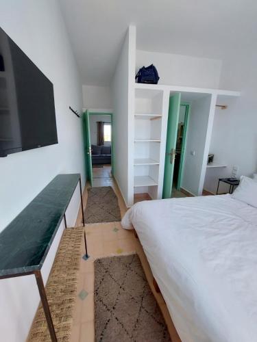 a bedroom with a bed and a tv on the wall at Sakia Talamanzou in Talamennzou
