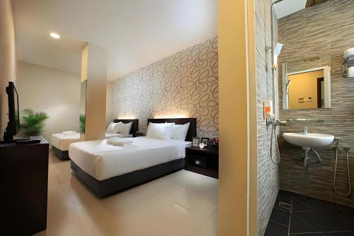 a bedroom with a bed and a sink and a bathroom at Izumi Hotel Bukit Bintang Kuala Lumpur in Kuala Lumpur
