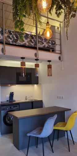 - une cuisine avec une table, deux chaises et une cuisinière dans l'établissement Le Lodge de Bandol, à Bandol