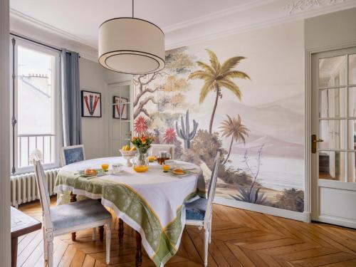 une salle à manger avec une table et un tableau au mur dans l'établissement Paris Arc de Triomphe Residence, à Paris