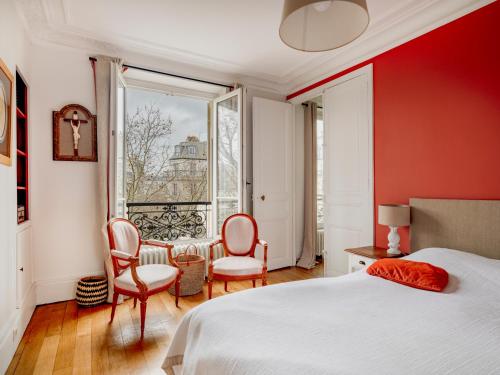 une chambre avec un lit et deux chaises et une fenêtre dans l'établissement Paris Arc de Triomphe Residence, à Paris