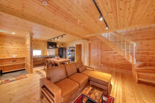 a living room with a couch and a staircase at 果樹園グランピングヴィラHARASAWA in Minakami
