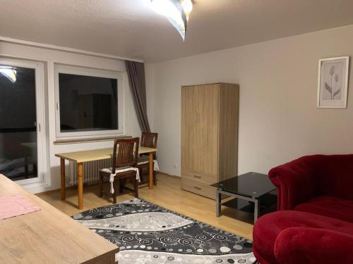 a living room with a red couch and a table at Solinger Ferienwohnung in Solingen
