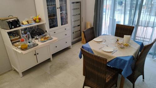 a dining room with a table and a kitchen at Residence Aurora Wellness & Spa in Albenga