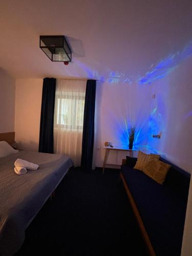 una camera con un letto e una finestra con luci blu di SZiGET23 ad Ábrahámhegy