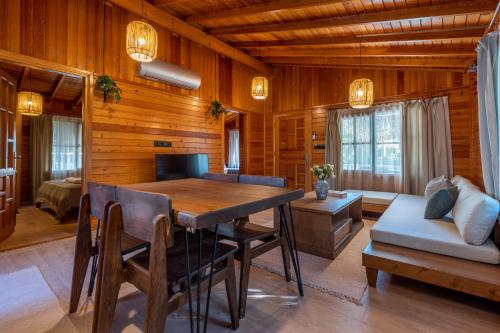 a dining room with a table and a couch at Naturelife Bungalows & SPA in Cıralı