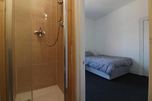 a bathroom with a shower next to a bed at Pebbles guest house room 5 in Southampton