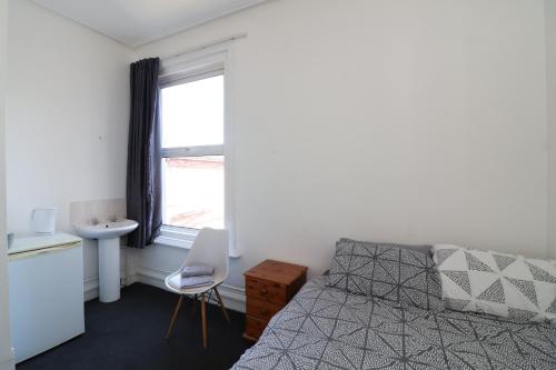 a bedroom with a bed and a sink and a window at Pebbles guest house room 5 in Southampton