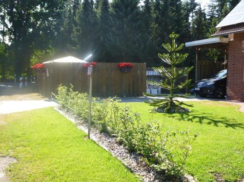 a yard with a fence and a garden with flowers at Angelikas Ferienparadies Angelika OG in Haselünne