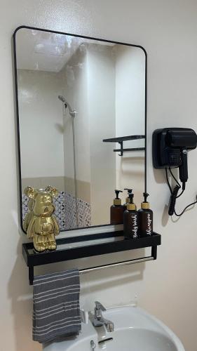 a mirror above a sink in a bathroom at FLEXI Staycation in Manila