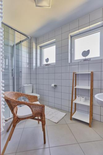 a bathroom with a chair and a sink at AVILA in Niechorze