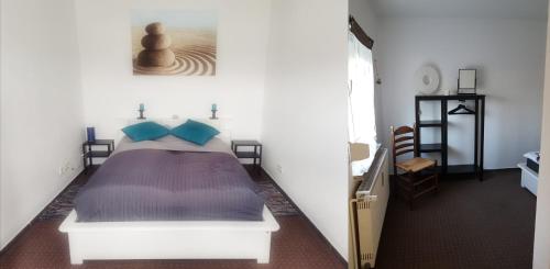 a bedroom with a white bed with blue pillows at Ferienwohnungen Auszeit am Geiseltalsee in Stöbnitz