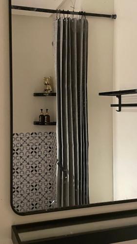 a mirror reflecting a shower curtain in a bathroom at FLEXI Staycation in Manila