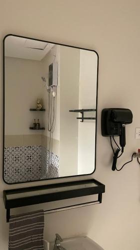 a mirror above a sink in a bathroom at FLEXI Staycation in Manila