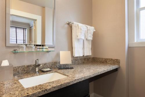 a bathroom with a sink and a mirror and towels at Executive Hotel Vintage Court in San Francisco