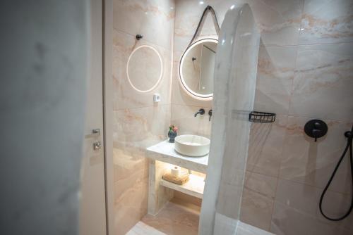 a bathroom with a sink and a shower with mirrors at Katerina Roza Studios - Heartfelt Hospitality in the City in Naxos Chora