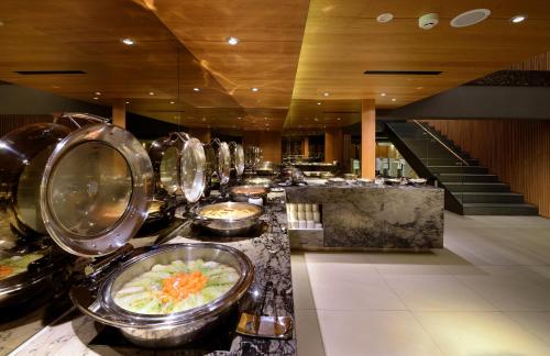 a buffet line with bowls of food in a restaurant at Hualien Holiday Hotel in Hualien City