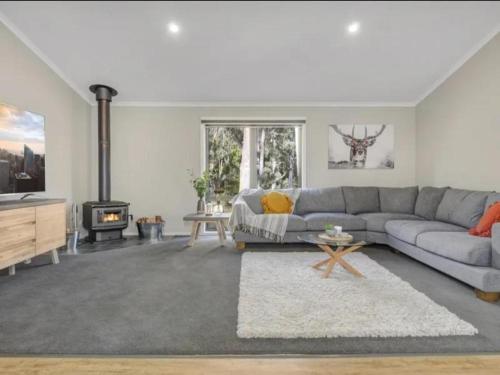 a living room with a couch and a fireplace at Sawmill Chalet - Located base of Mt Buller in Merrijig