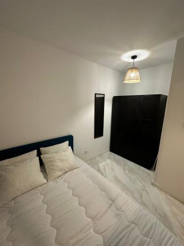 - une chambre avec un grand lit blanc et une lumière dans l'établissement Appartement 1 minute de la promenade des Anglais, à Nice
