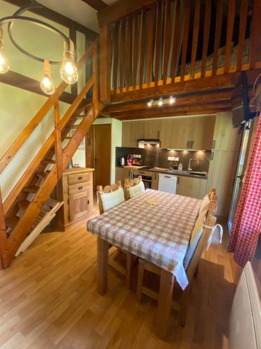 une chambre avec une table et une cuisine avec des escaliers dans l'établissement Chalet mitoyen pres des pistes, à Bolquère-Pyrénées 2000