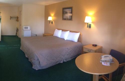 a hotel room with a bed and a table at Black Canyon Motel in Montrose