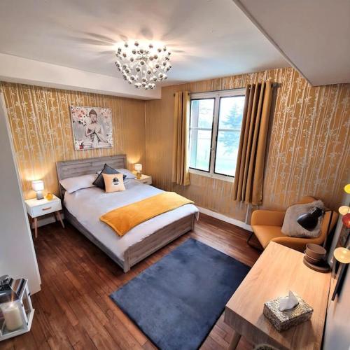 une chambre avec un grand lit et un lustre dans l'établissement Navaleuil, à Mézières-sur-Issoire