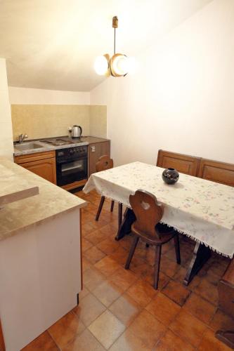 a kitchen with a table and chairs in a kitchen at Lush Garden Hideaway FAMA near Portoroz in Sečovlje