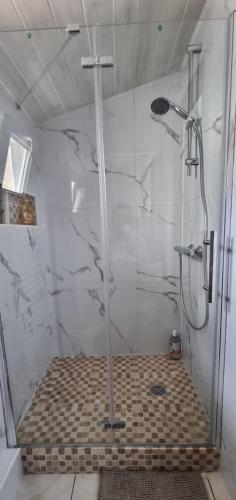 La salle de bains est pourvue d'une douche et de carrelage. dans l'établissement Studio aux deux terrasses, à Puiseux-en-France