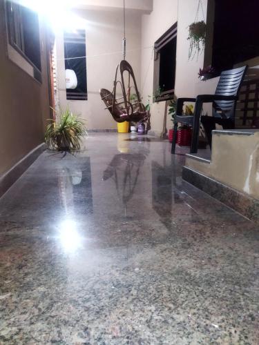 a living room with a concrete floor and chairs at Sahana Villa in New Hampi
