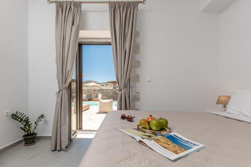 a bedroom with a bed with a tray of fruit on it at Marble Arch Apartments in Naxos Chora