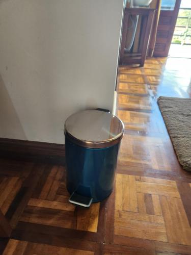 a blue trash can sitting on a wooden floor at MANGORO HOTEl in Moramanga
