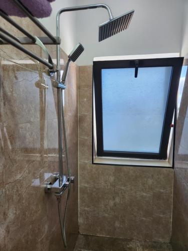 a shower with a large window in a bathroom at MANGORO HOTEl in Moramanga