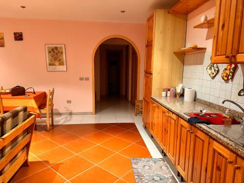 een keuken met houten kasten en een oranje tegelvloer bij Casa di Fra in Cotronei