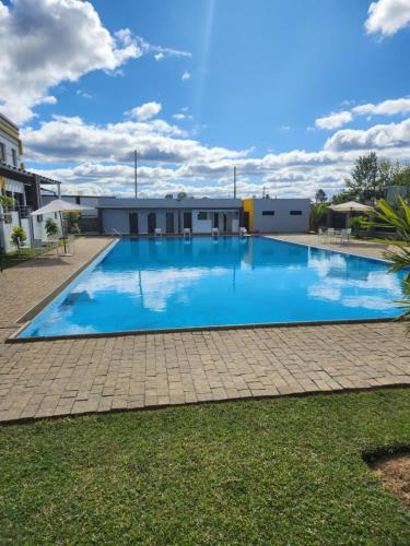 a large blue swimming pool with a building in the background at MANGORO HOTEl in Moramanga