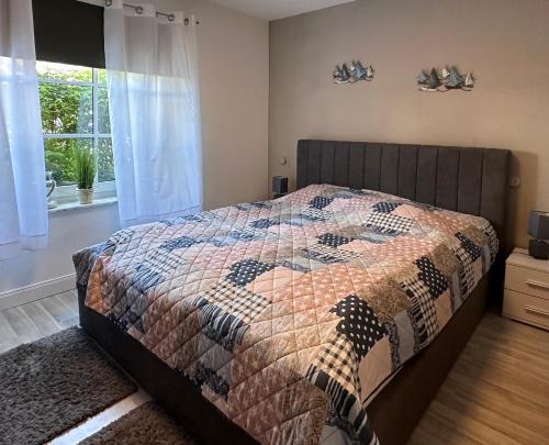 een slaapkamer met een bed met een quilt bij Strandläufer in Schönhagen