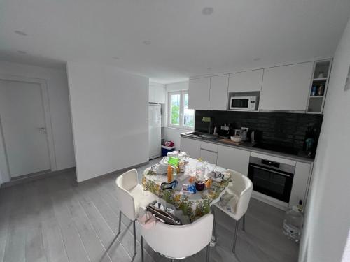 a white kitchen with a table and chairs in it at Old and cute renovated house 100m from the sea in Trogir