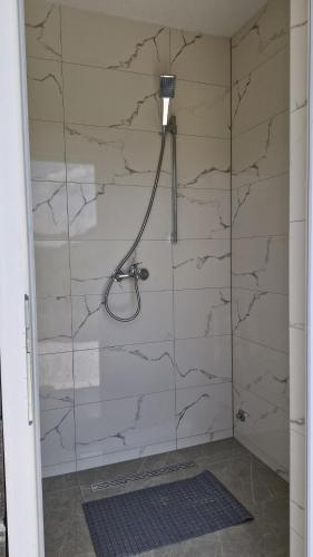 a shower with a glass door in a bathroom at Autokamp OAZA MIRA RAMA in Ripci