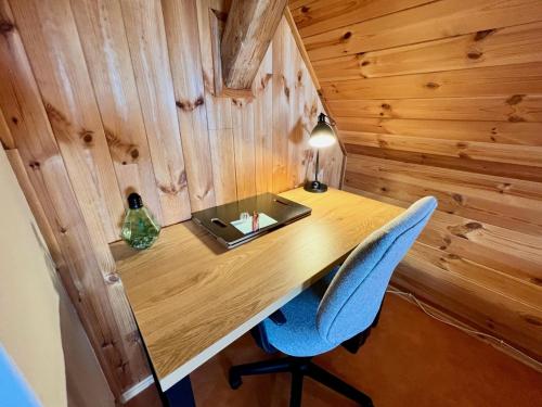 a wooden desk with a blue chair and a lamp at Holiday Home Celine in Velké Svatoňovice
