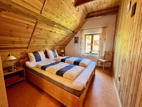 a bedroom with a large bed in a log cabin at Holiday Home Celine in Velké Svatoňovice