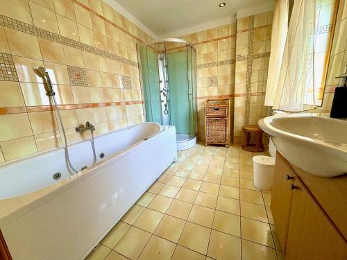 a bathroom with a tub and a sink at Holiday Home Celine in Velké Svatoňovice