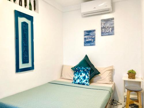 - une chambre avec un lit doté d'oreillers bleus et blancs dans l'établissement Balai Lawaan Cozy Homestay, à Iloilo