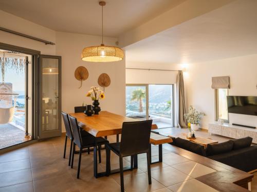 a dining room and living room with a table and chairs at Youtopia Ios Villas in Ios Chora