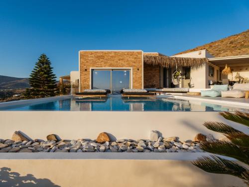 a swimming pool with a house at Youtopia Ios Villas in Ios Chora