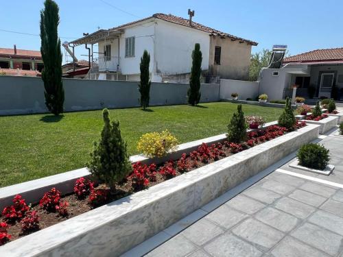 a garden with flowers and plants in a yard at Kariofilli's house in Áyios Athanásios