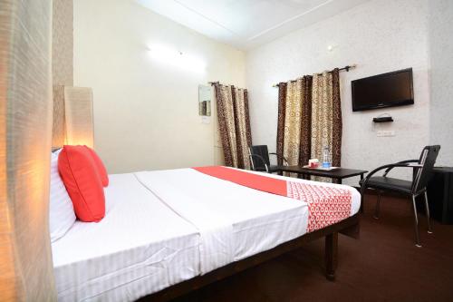 een hotelkamer met een bed en een televisie bij Super OYO Urban Guest House in Patiala