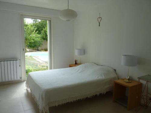 une chambre blanche avec un lit et une grande fenêtre dans l'établissement Villa 10 Pers Piscine proche Plage Carnon, à Pérols