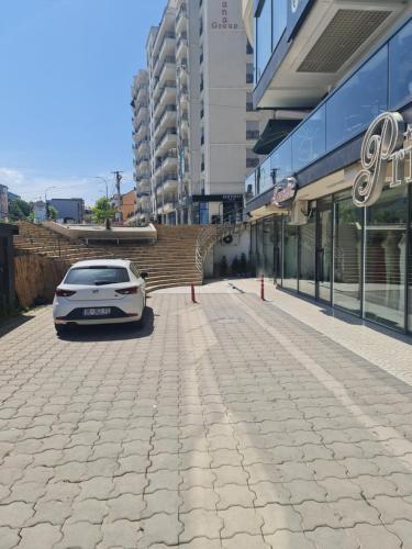 a white car parked in front of a building at Apartment 2 Plisi Gjilan in Gjilan