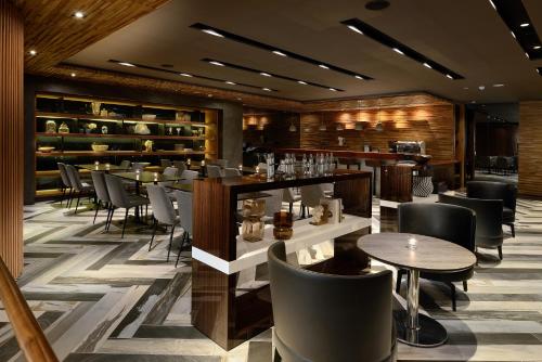 a restaurant with tables and chairs and a bar at Hualien Holiday Hotel in Hualien City